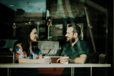 Homme et femme discutant autour d'un café.