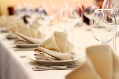 Banquet, table avec couverts, services, verres à vin.