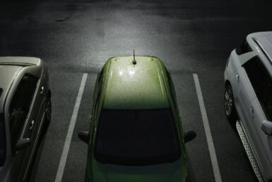 Voiture verte garée sur une place de parking.