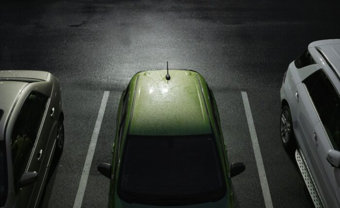 Voiture verte garée sur une place de parking.